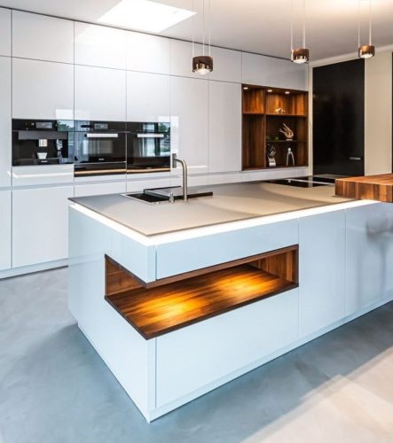 Image of a modern kitchen featuring white cabinets and wooden counter tops.