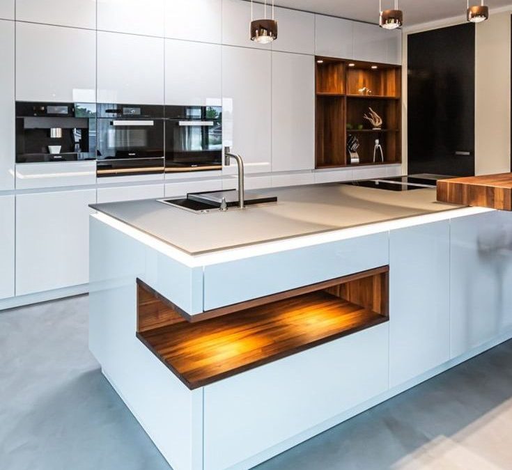 Image of a modern kitchen featuring white cabinets and wooden counter tops.