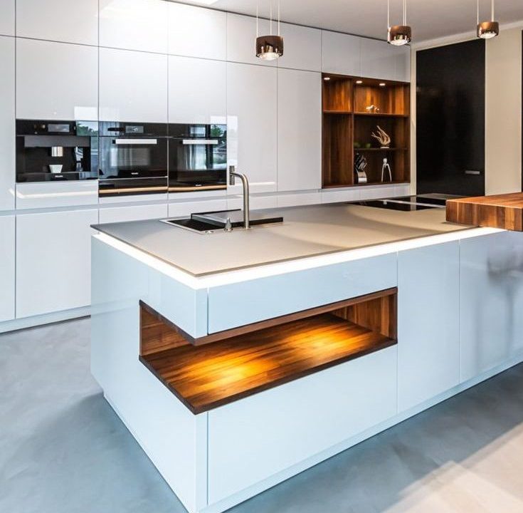 Image of a modern kitchen featuring white cabinets and wooden counter tops.